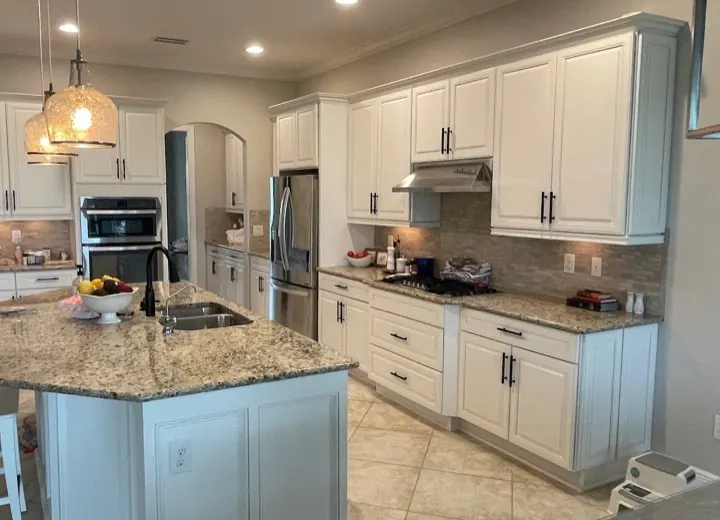 Large white kitchen with island refinished, granite countertop and stainless appliances