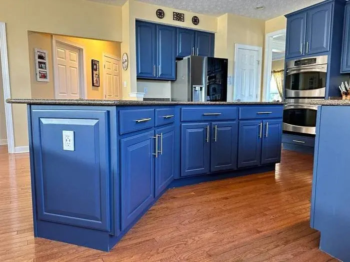Kitchen island cabinets in bold navy blue with chrome bar pulls